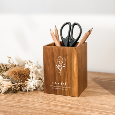 A wooden pencil holder with a floral design and a personalized engraving that reads 'Thank you for helping me grow - Teacher Gift.